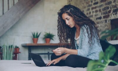 Average credit card debt in 2026 — person reviewing credit card bills and finances online