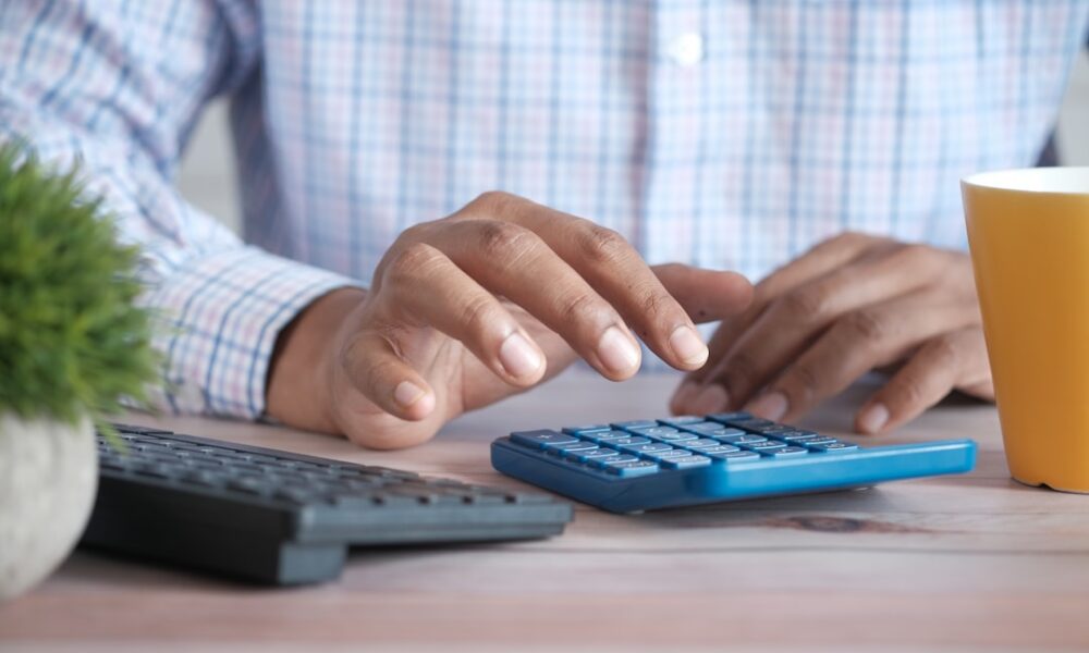 Debt consolidation vs balance transfer comparison shown with calculator and bills