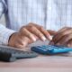 Debt consolidation vs balance transfer comparison shown with calculator and bills