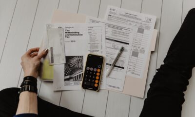 Person calculating debt consolidation loan payments with a calculator and bills