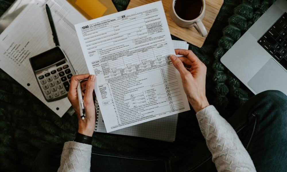 Debt settlement vs bankruptcy paperwork with calculator and laptop used to compare payoff costs