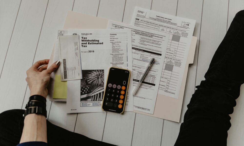 Calculator and paperwork used to work out debt-to-income ratio