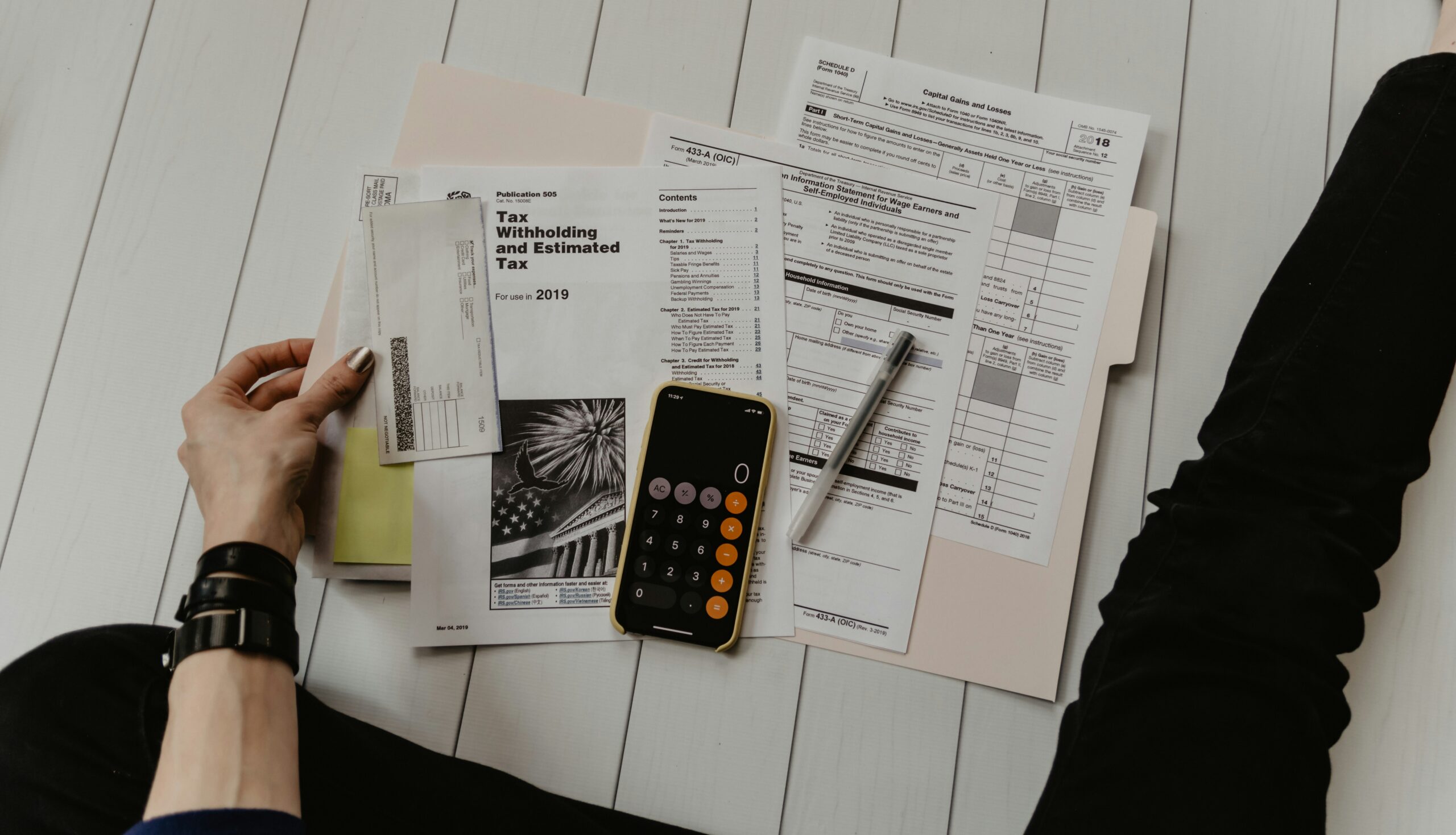 Calculator and paperwork used to work out debt-to-income ratio