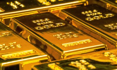Gold bars representing gold vs stocks vs real estate comparison