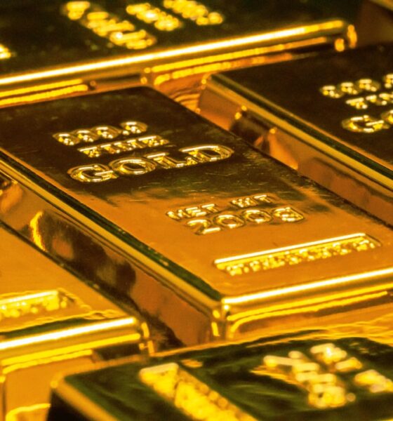Gold bars representing gold vs stocks vs real estate comparison