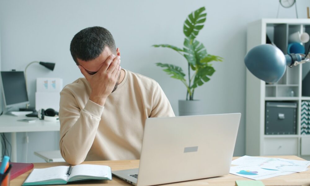 Stressed worker reviewing paycheck and bills, illustrating how to stop wage garnishment for debt