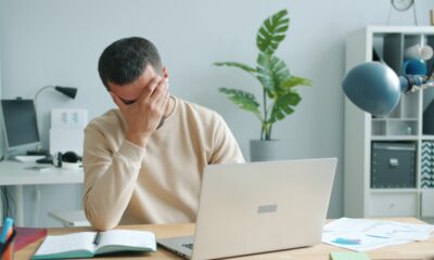 Stressed worker reviewing paycheck and bills, illustrating how to stop wage garnishment for debt