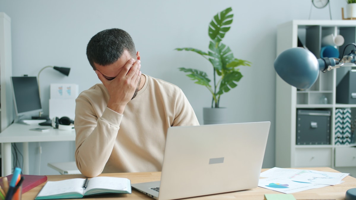 Stressed worker reviewing paycheck and bills, illustrating how to stop wage garnishment for debt