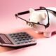 Calculator and piggy bank illustrating the decision to pay off debt or invest first