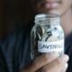 Saving habits jar with coins representing steps toward financial independence