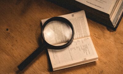 FICO score vs VantageScore comparison shown with a credit report and magnifying glass